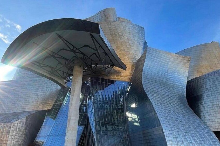 A modern architectural building with a unique, curved design and reflective surfaces. 5