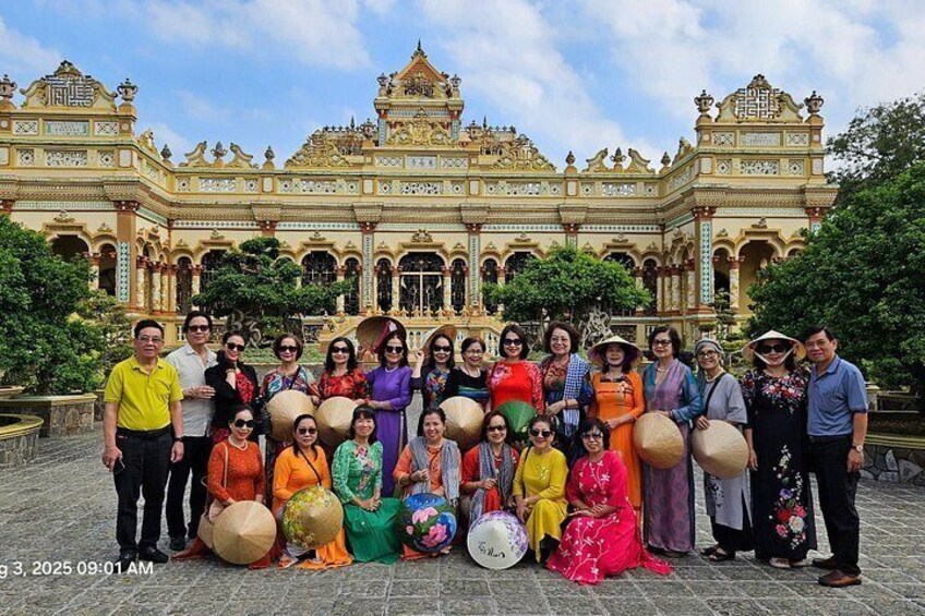 A group of people in front of a large, ornate building with intricate architecture. 4