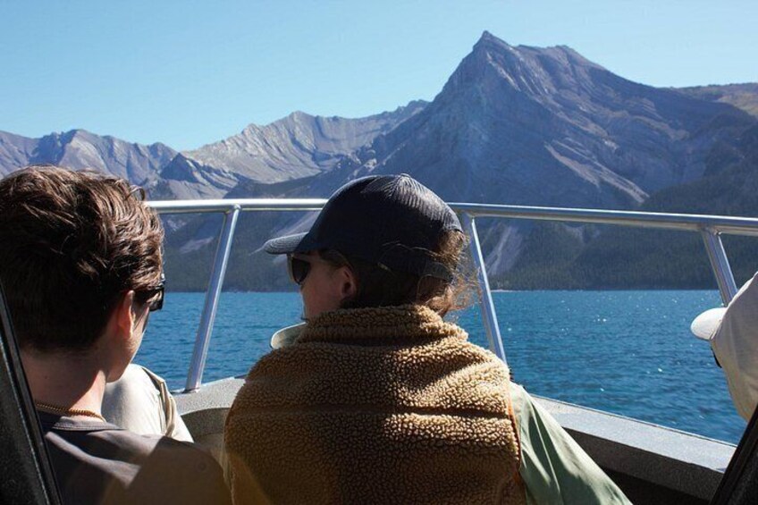 Un bote con dos personas frente a un paisaje montañoso. 2