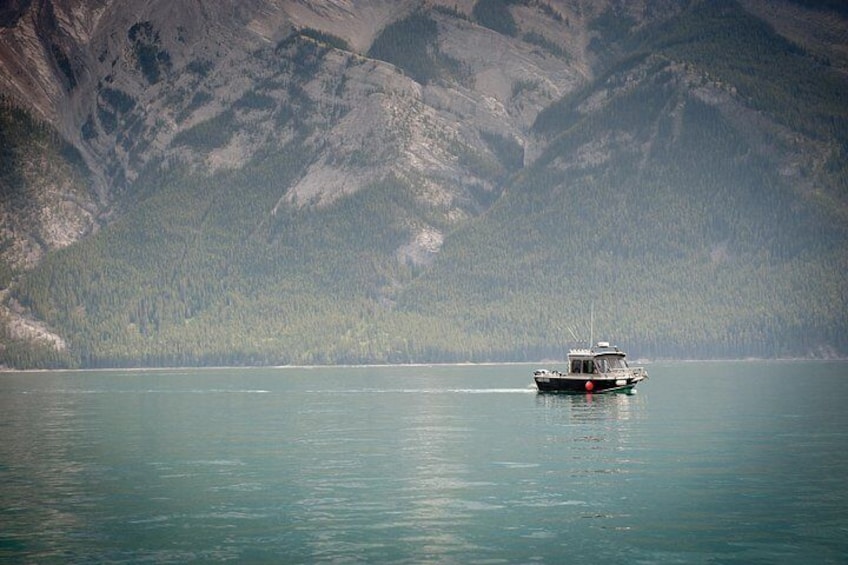 A boat on a calm lake with mountains in the background. 2