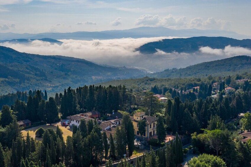 Un paysage montagneux avec un village niché au milieu des arbres, une église et des collines ondulantes en arrière-plan. 2