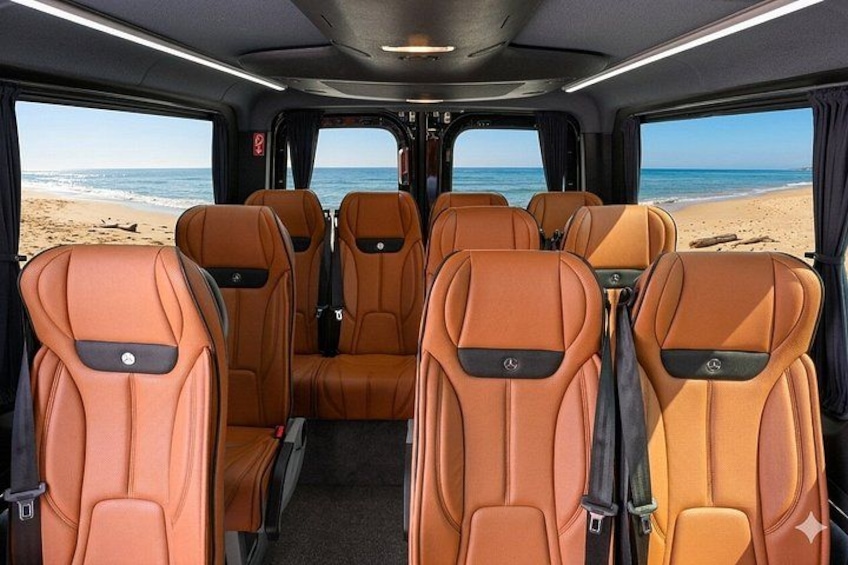 A vehicle interior with orange seats and a view of the beach. 3