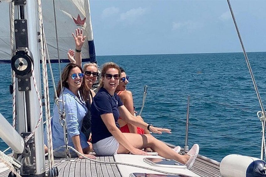 Un velero con gente en la cubierta, un mar azul cristalino y un cielo despejado. 2