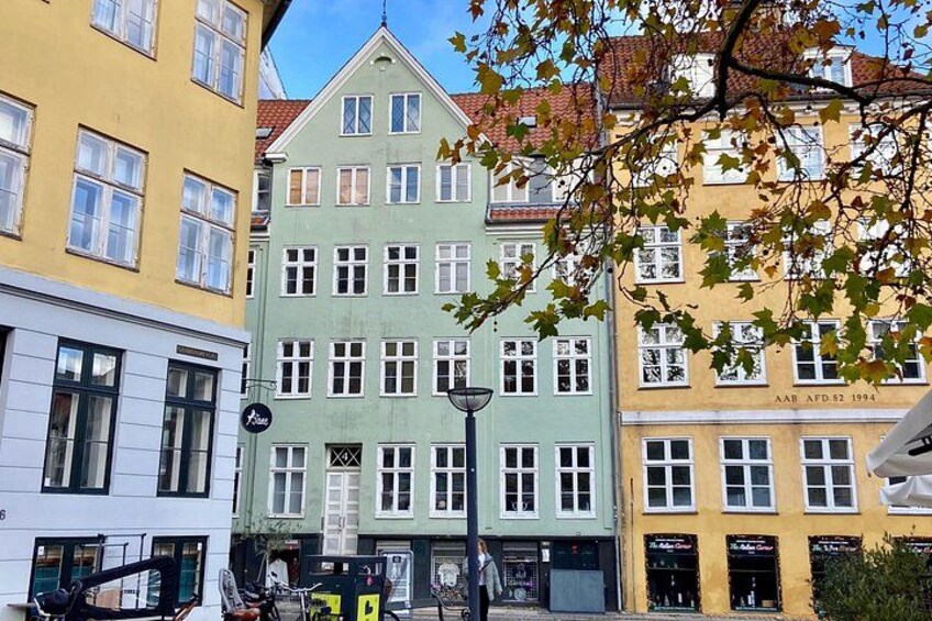 En gata med färgglada byggnader, en gatlykta och en cykel. 4
