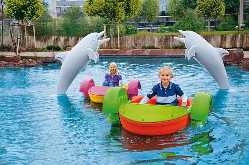 A swimming pool with inflatable boats and dolphin sculptures. 4