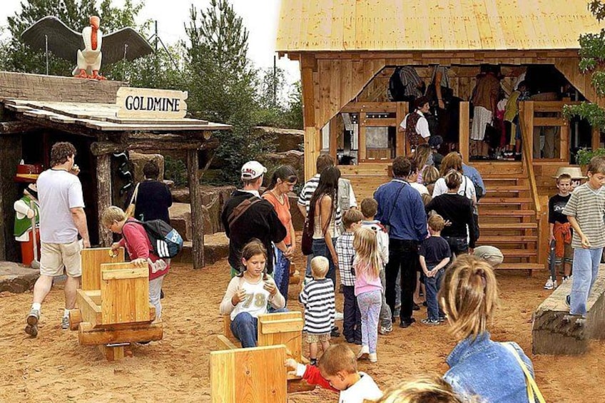 A rustic wooden building labeled 'GOLDMINE' with a staircase leading to an upper level. 5