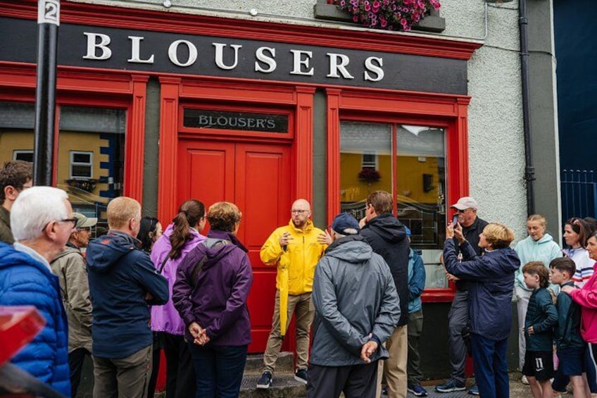 A crowd outside a building with a red door and the sign 'BLOUSERS'. 3