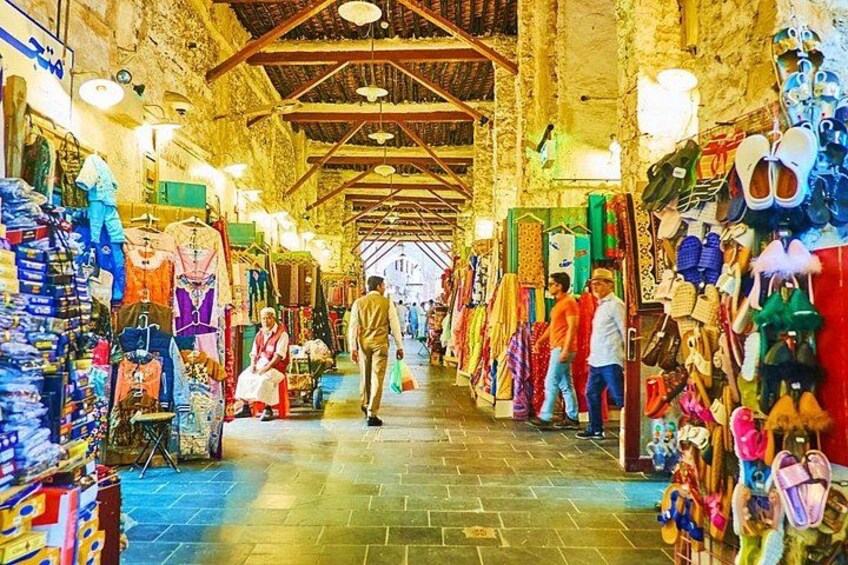 Un marché couvert animé où l’on trouve de nombreux stands vendant des vêtements et des chaussures. 4