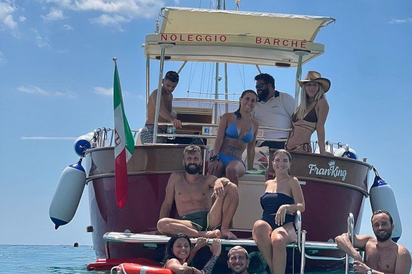 A boat with people on board, Italian flag, and the name 'Franco King' on the side. 2