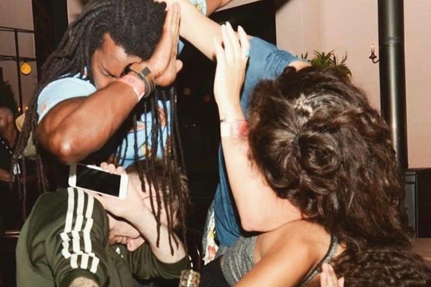A person with dreadlocks holding a smartphone. 5