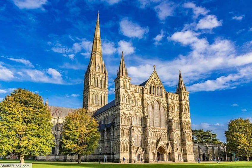 A large Gothic cathedral with two tall spires, surrounded by trees and a clear blue sky. 3