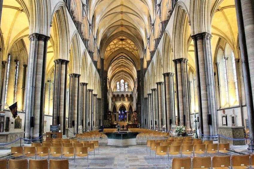 A cathedral interior with high vaulted ceilings, rows of chairs, and a central altar. 4