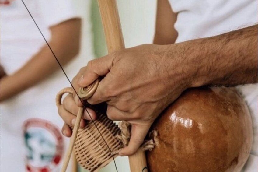 A person using a weaving tool on a loom. 2