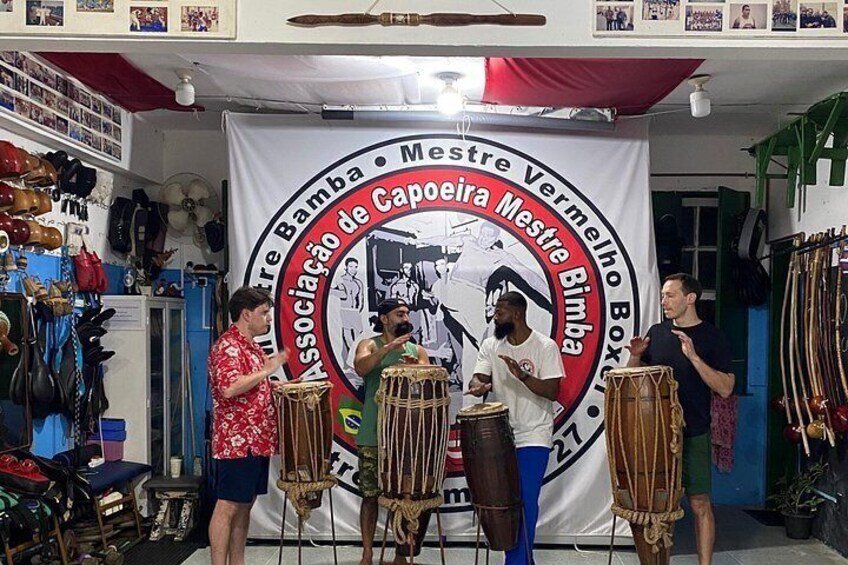 A drum circle with a banner reading 'Associação de Capoeira Mestre Vermelho Box.' 3