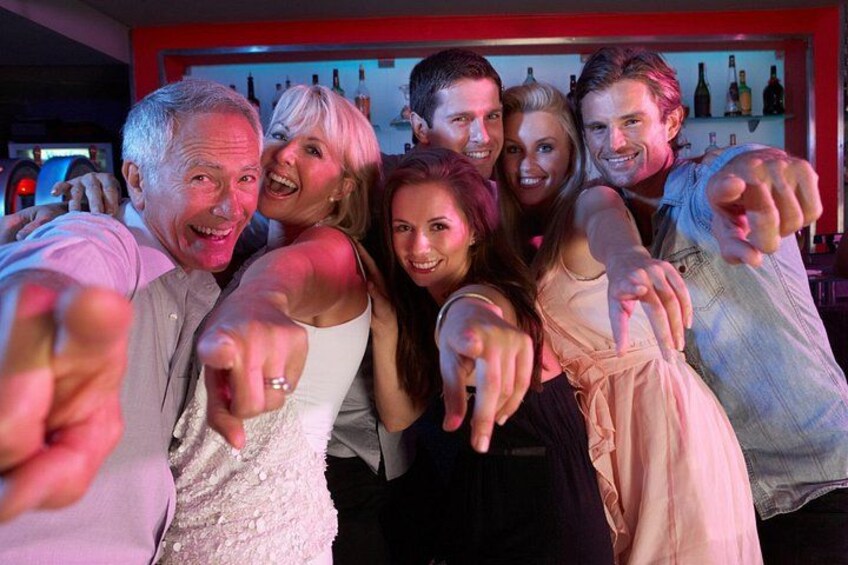 A group of people at a bar with bottles in the background. 3
