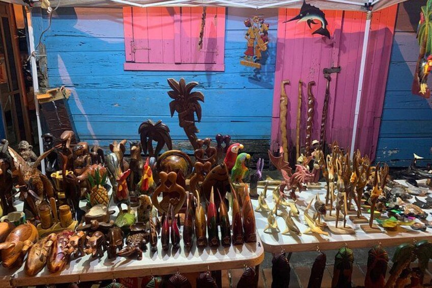 A variety of wooden carvings and sculptures displayed on tables. 2