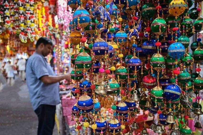 Un mercato con addobbi colorati appesi e una persona che curiosa. 2