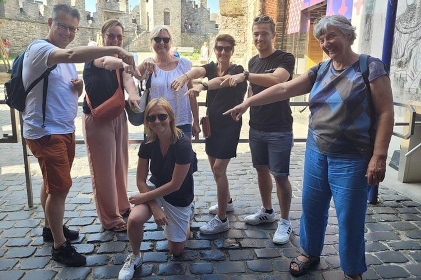 Un grupo de personas posando en una calle adoquinada con edificios históricos al fondo. 2