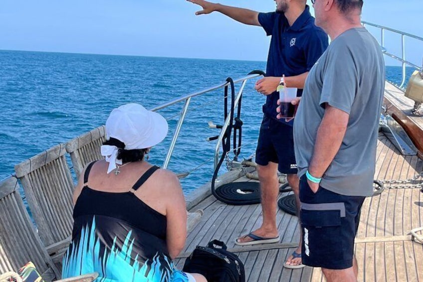 Una barca con persone sul ponte, l'oceano sullo sfondo. 3