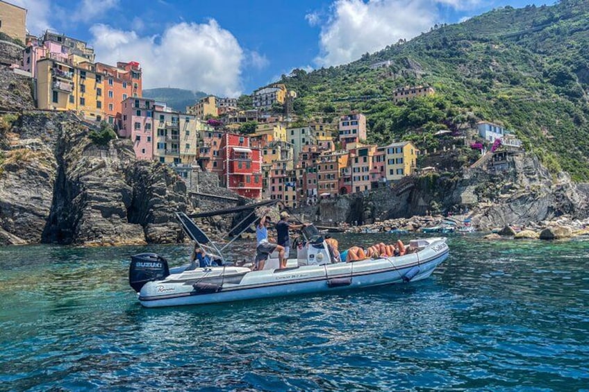 A boat with people on a coastal village with colorful buildings. 2