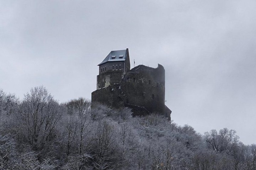 A medieval castle on a hill with a cloudy sky. 2