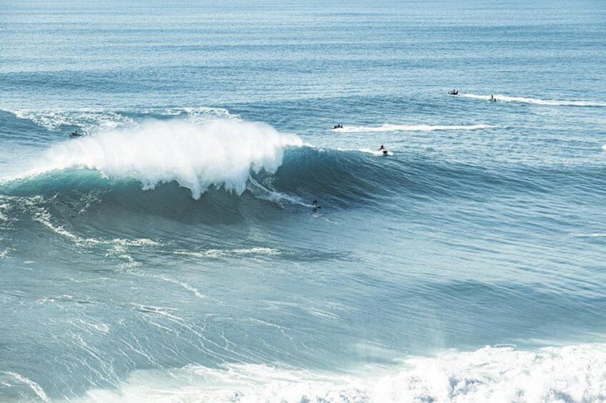 A large wave with surfers riding it. 5
