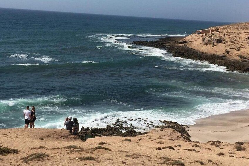 A beach with waves crashing onto the shore, a sandy beach, and rocky outcrops. 1