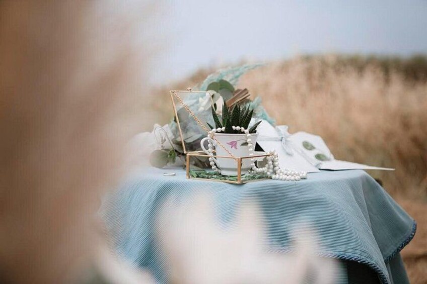 A table set outdoors with a blue tablecloth, decorative items, and a natural landscape in the background. 4