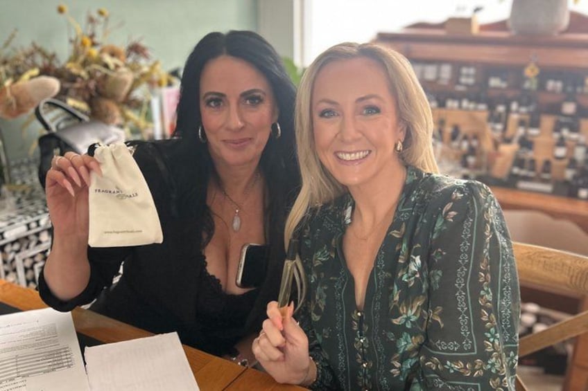 Two people sitting at a table with a small white bag and a smartphone. 3