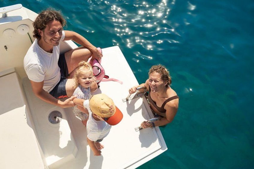 Una barca con persone a bordo, un bambino con un cappello, e acqua cristallina. 4