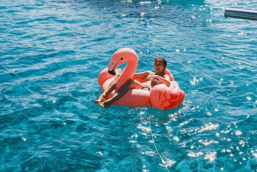 A person floating on a pink flamingo float in a pool. 2