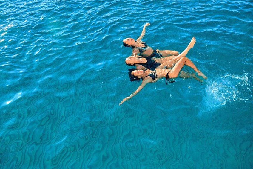 A person floating on a clear blue pool. 2