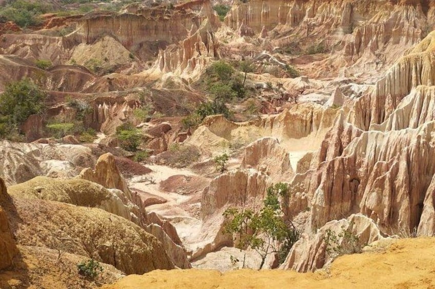 A rugged, eroded landscape with sharp rock formations and sparse vegetation. 3