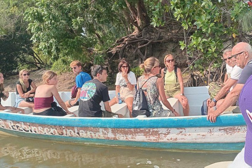 A group of people on a boat, surrounded by trees and water. 2