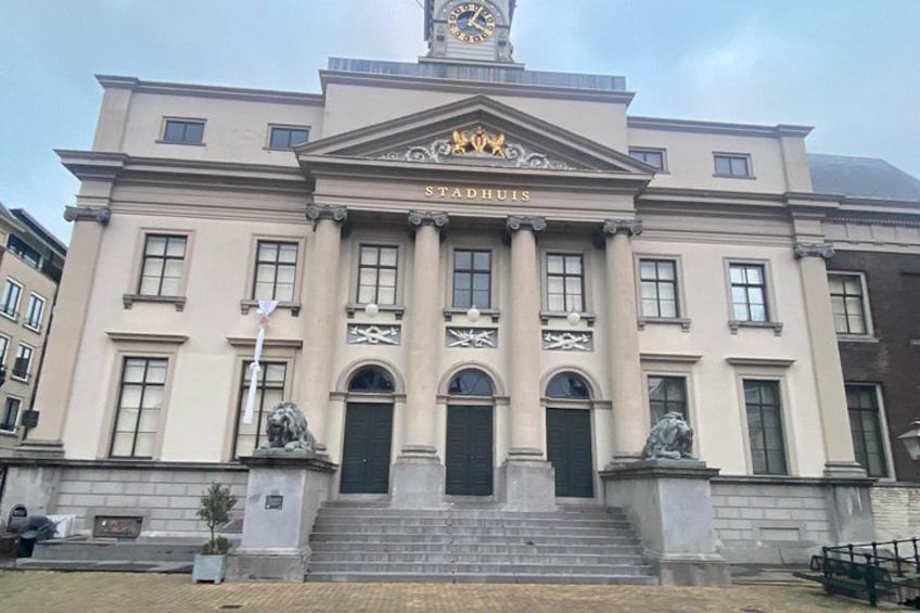 Un edificio imponente con una torre de reloj, columnas y estatuas. 3