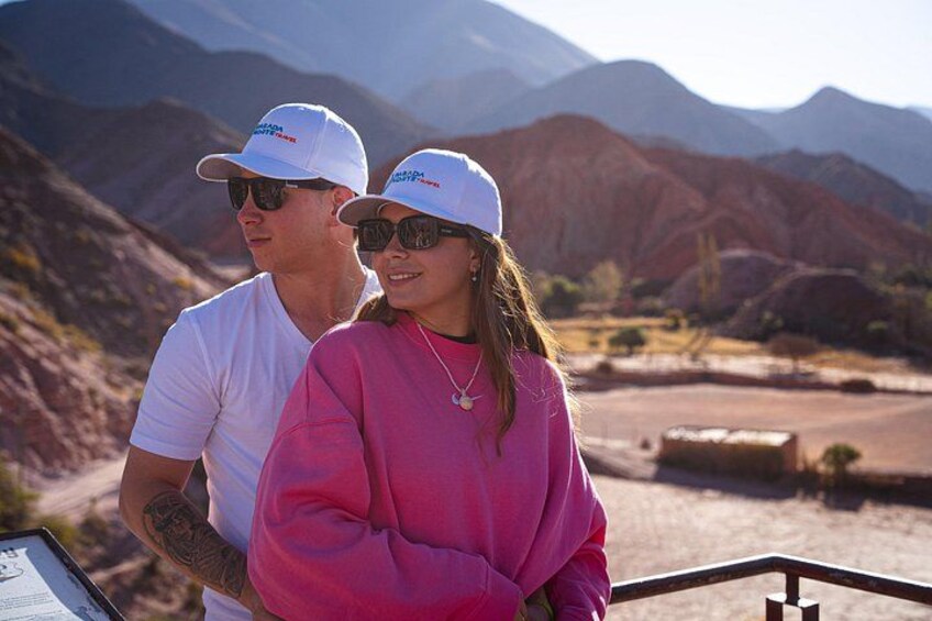 Una pareja parada en un bote con un paisaje montañoso al fondo. 2