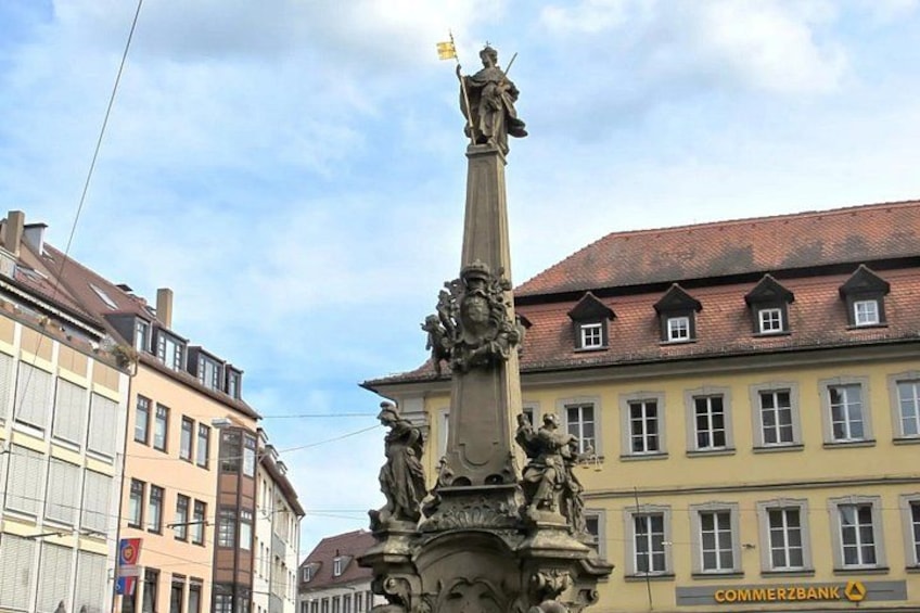 Een historisch monument met beelden, omgeven door klassieke Europese architectuur. 3