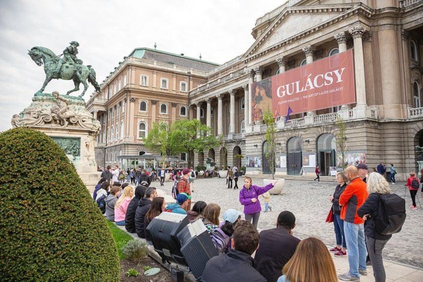 Un edificio histórico con una estatua, una multitud de personas y un cartel que dice 'GULÁCSY'. 3