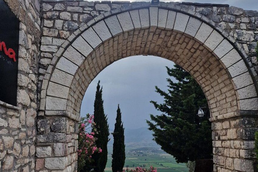 A stone archway with a view of a mountainous landscape. 5