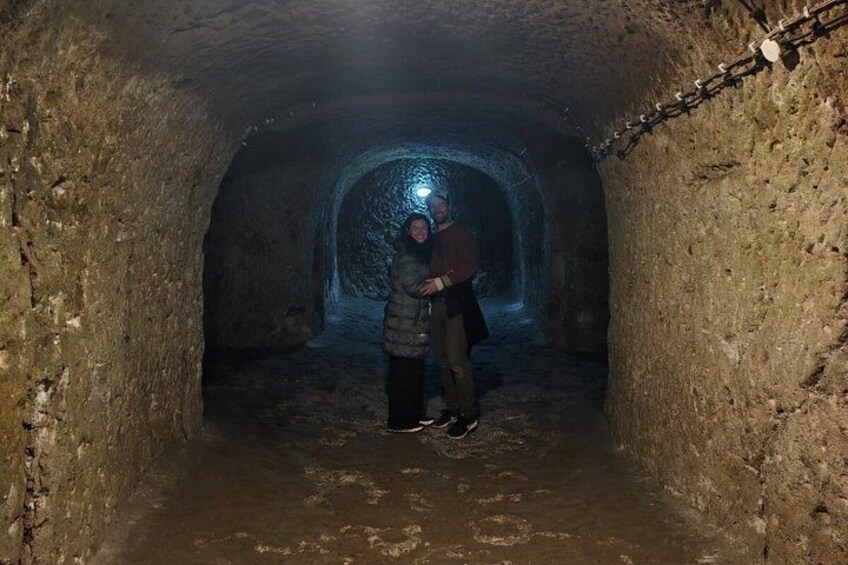 A person standing in a tunnel with a light source at the end. 2