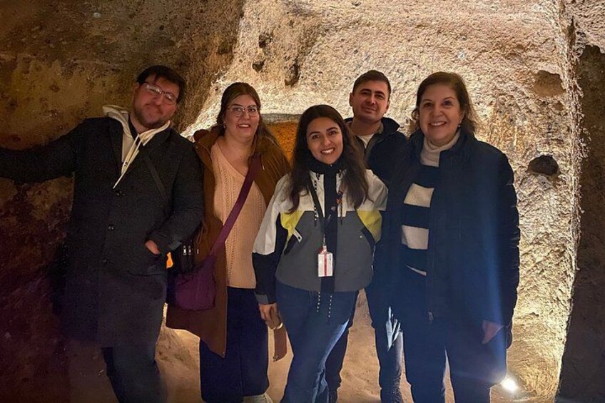 A group of people inside a cave with rough stone walls. 5