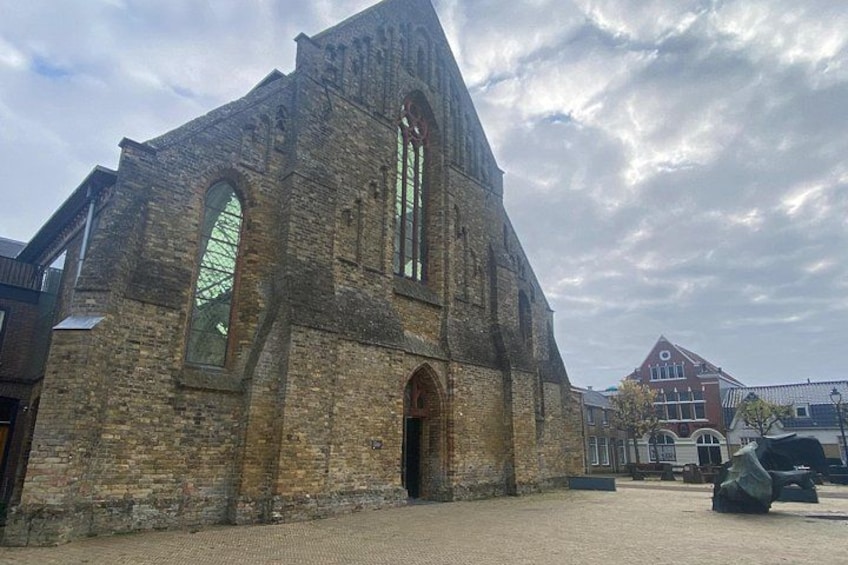 An old brick church with arched windows and a large central archway. 2