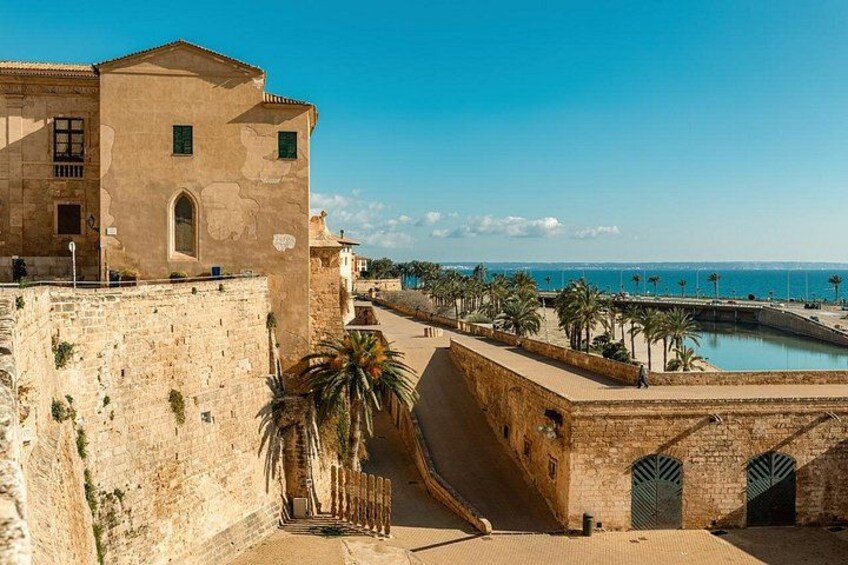 Paesaggio costiero con architettura storica, un muro fortificato e un mare blu limpido. 5