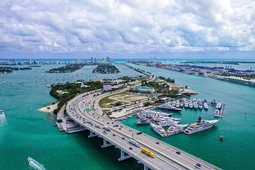 A coastal cityscape with a bridge, marina, and islands. 3