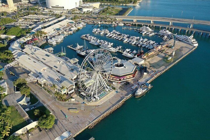 A marina with boats, a Ferris wheel, and a bridge. 2