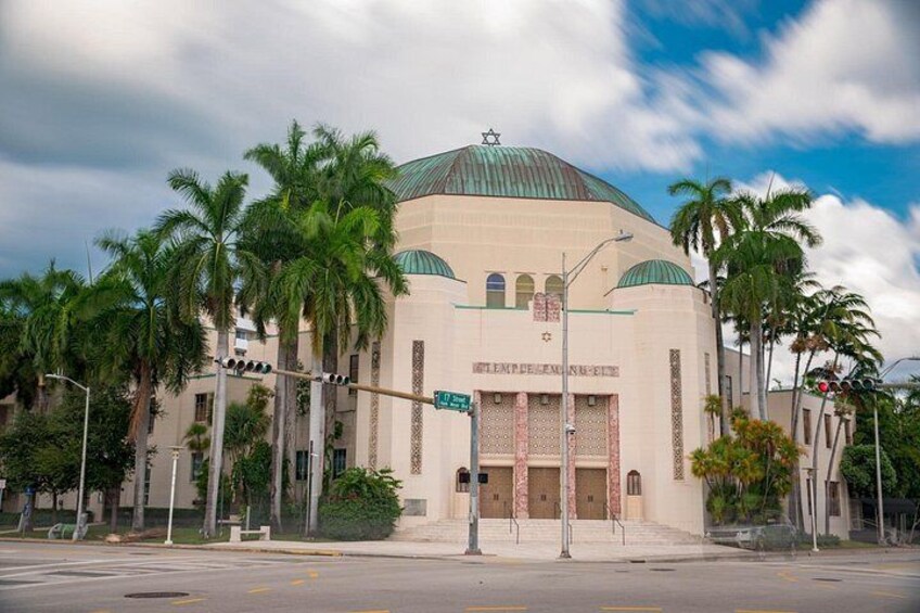 A mosque with a large dome and minarets, surrounded by palm trees. 1