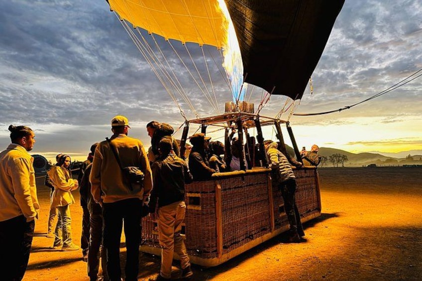 A hot air balloon with people preparing it on the ground. 3