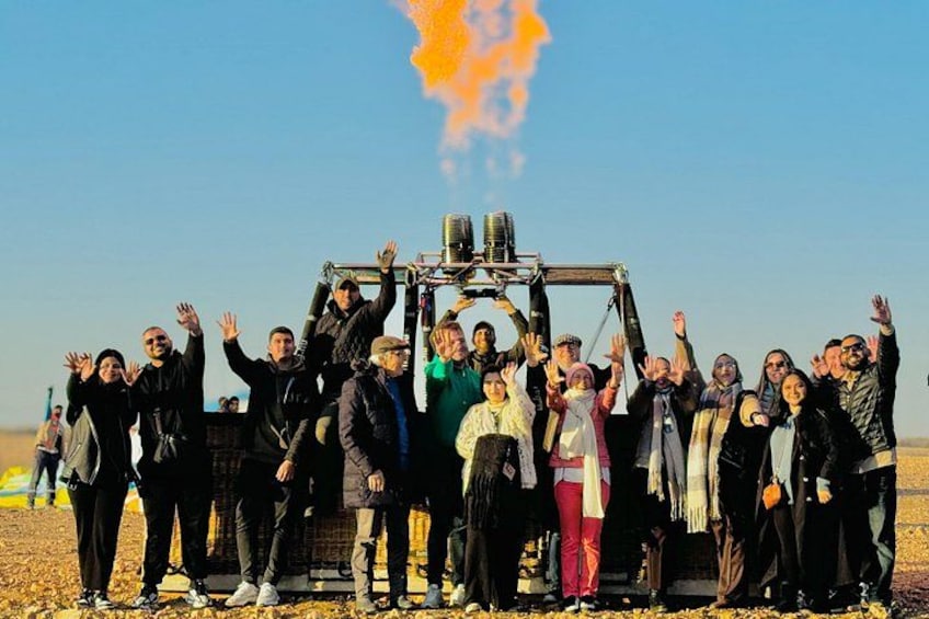 A group of people standing in a field with a vehicle in the background. 2