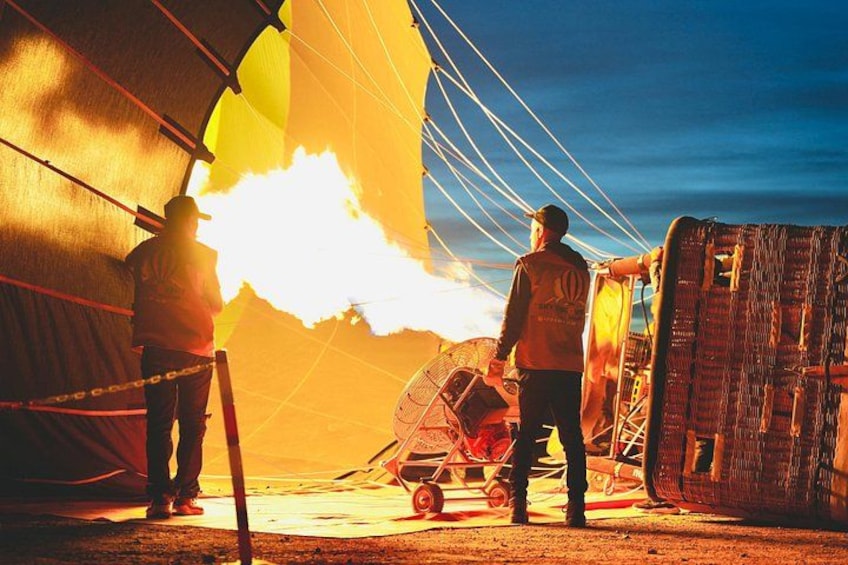 A large inflatable structure with flames, a person in a safety vest, and a vehicle. 4