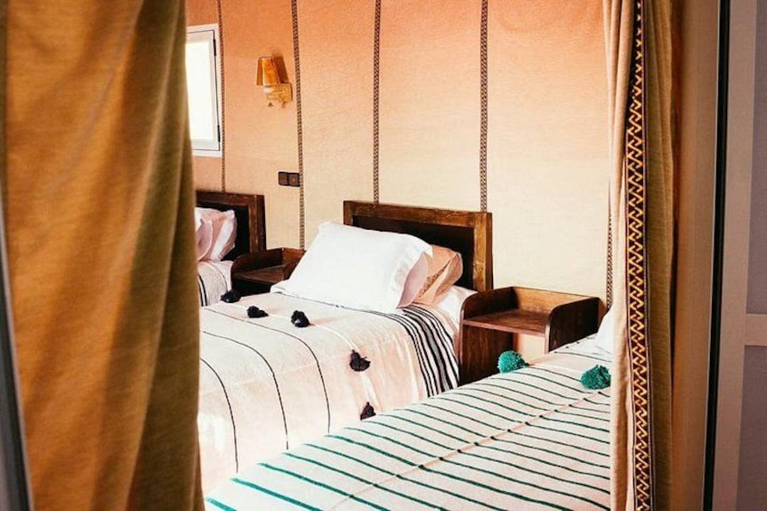 A bedroom with two beds, wooden headboards, and a hanging swing chair. 3